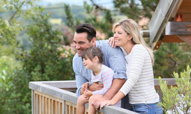 Famiglia felice guarda il panorama dal balcone.