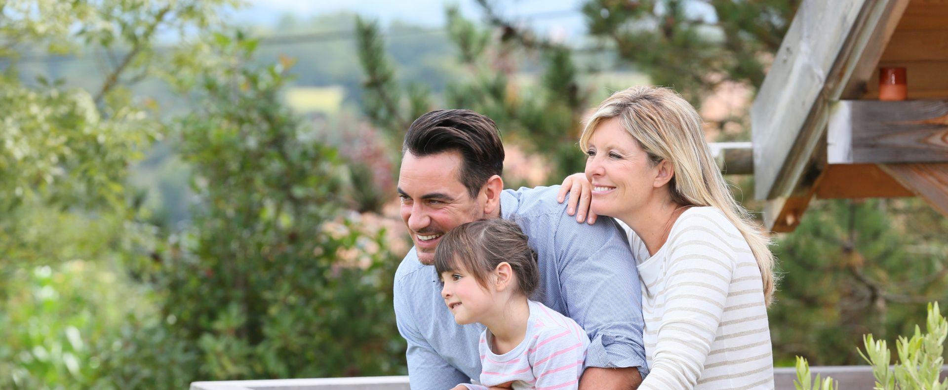 Famiglia felice che guarda il panorama da un balcone.