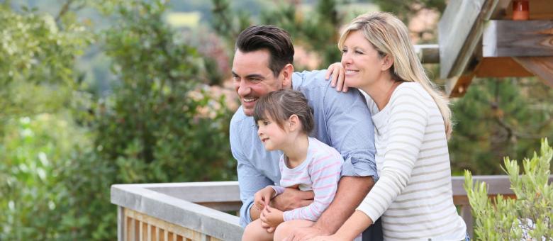 Famiglia felice che guarda il panorama da un balcone.